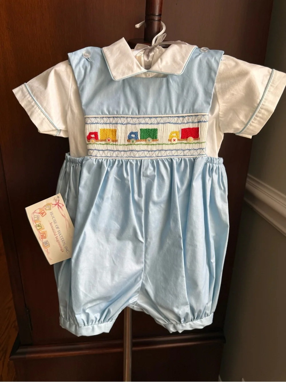 House of Hatten Smocked Blue & White Baby Romper with Colorful Truck Motif
